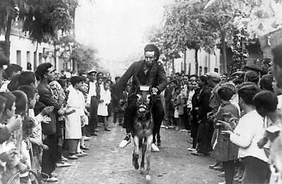 #ad Man riding a donkey during a race in the streets in 1928 in La Pro Old Photo